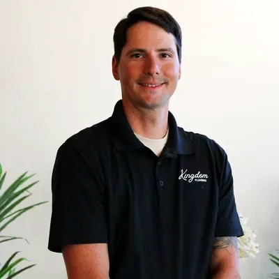 Kingdom Plumbing team member in a black company polo at the Las Vegas office