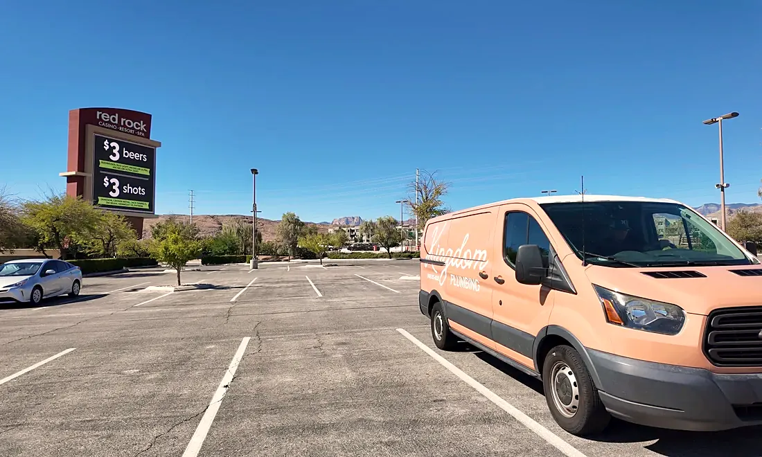 Kingdom Plumbing service van crossing a Las Vegas parking lot on the way to a job